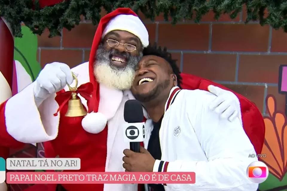Papai noel negro abraça repórter da Globo - Metrópoles