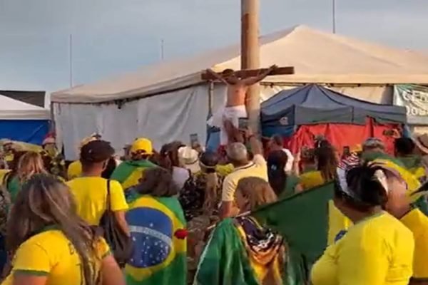 Pessoas com vestimenta do Brasil reunidas em praça