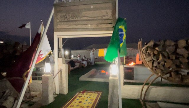 Na entrada do espaço da festa, as bandeiras do Brasil e do Catar e lenha para queimar nas fogueiras