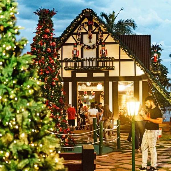 Fotografia colorida da casa do Papai Noel ao fundo e uma árvore natalina na frente-Metrópoles