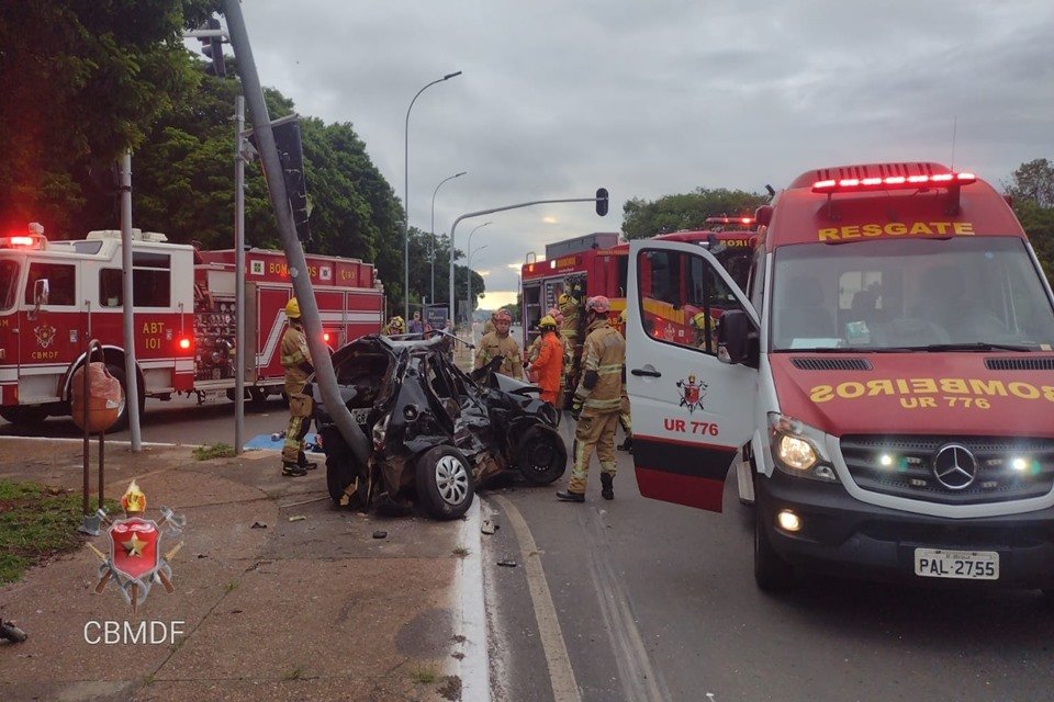 Carros do CBMDF em volta de carro preto que colidiu contra poste, na Esplanada dos Ministérios
