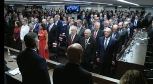 O presidente e vice eleitos Lula e Alckmin em meio a outros políticos e membros do governo de transição na posse do ministro do TCU, Bruno Dantas. Eles aparecem de pé na plateia de frente pra mesa com os ministros - Metrópoles