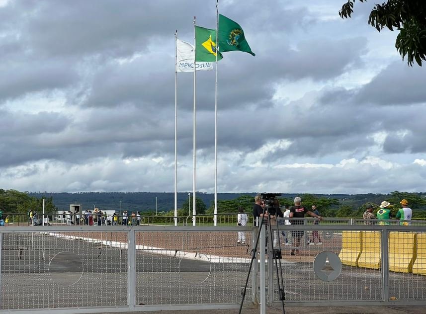 Frente do Palácio da Alvorada no momento da chegada do caminhão de mudança, com manifestantes e jornalistas acompanhando a movimentação - Metrópoles