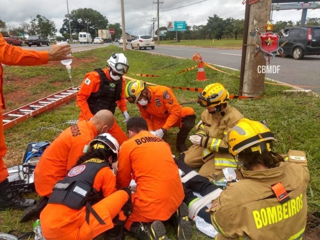 Militares do corpo de bombeiros socorrem homem deitado em maca. Foto colorida