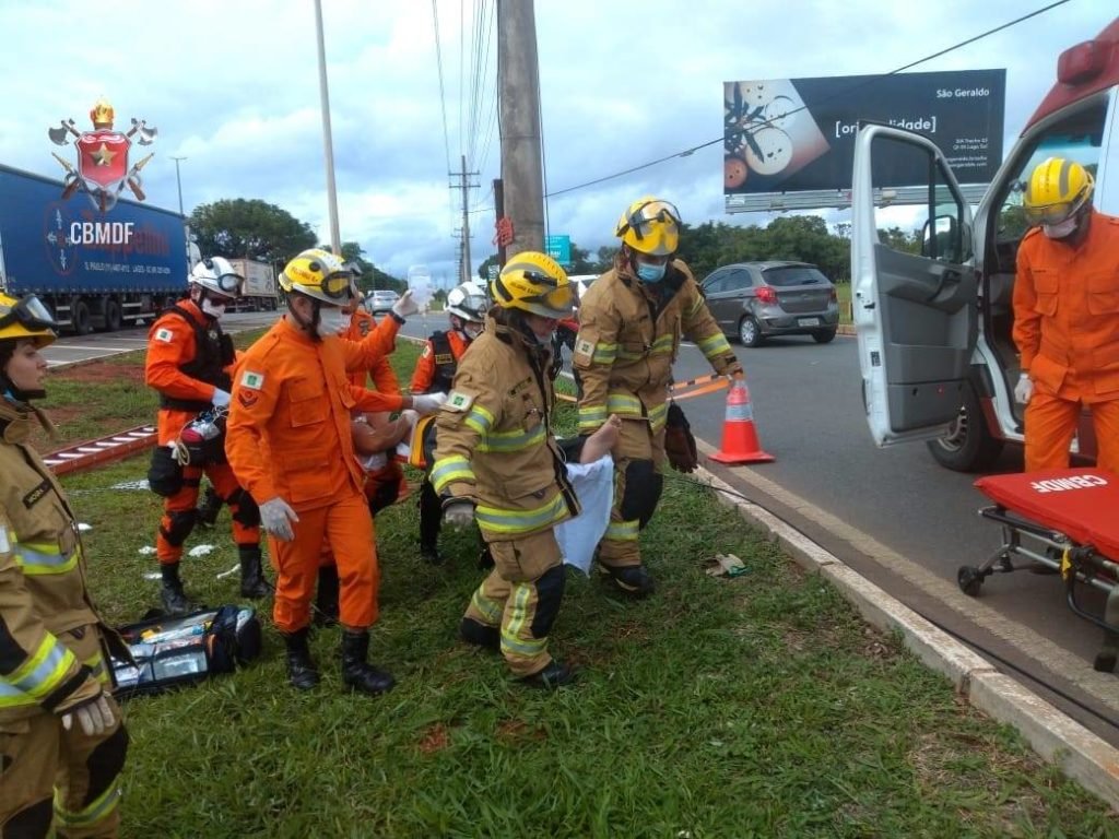 Militares do corpo de bombeiros socorrem homem deitado em maca. Foto colorida