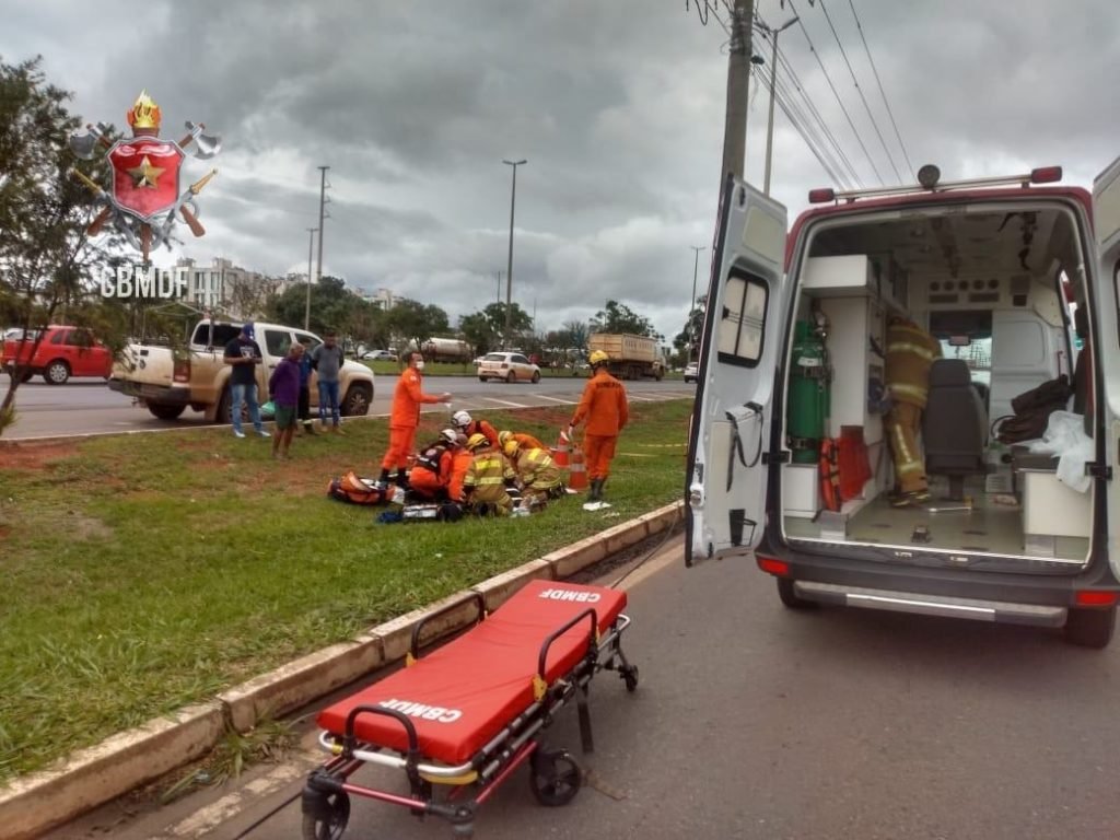 Militares do corpo de bombeiros socorrem homem deitado em maca. Foto colorida