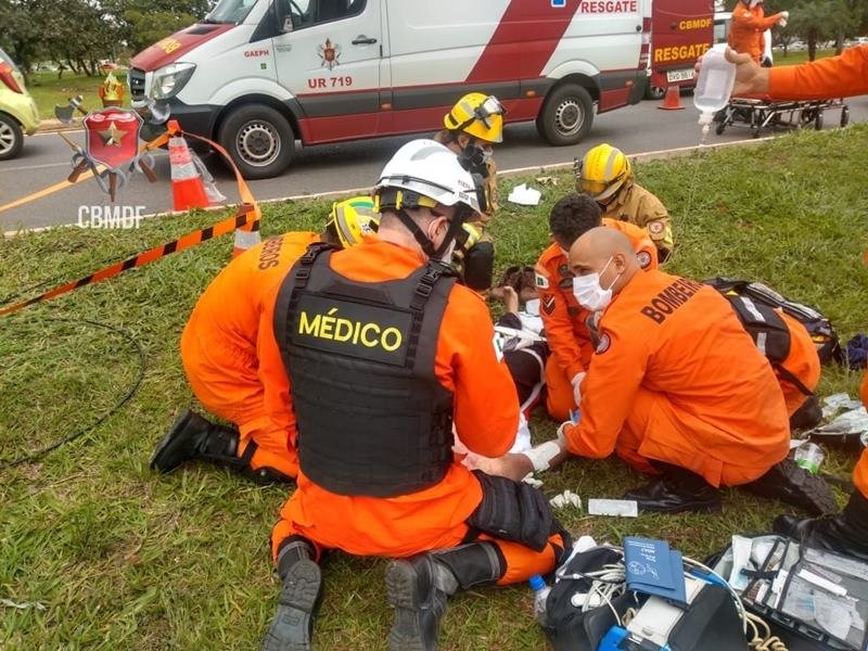 Militares do corpo de bombeiros socorrem homem deitado em maca. Foto colorida