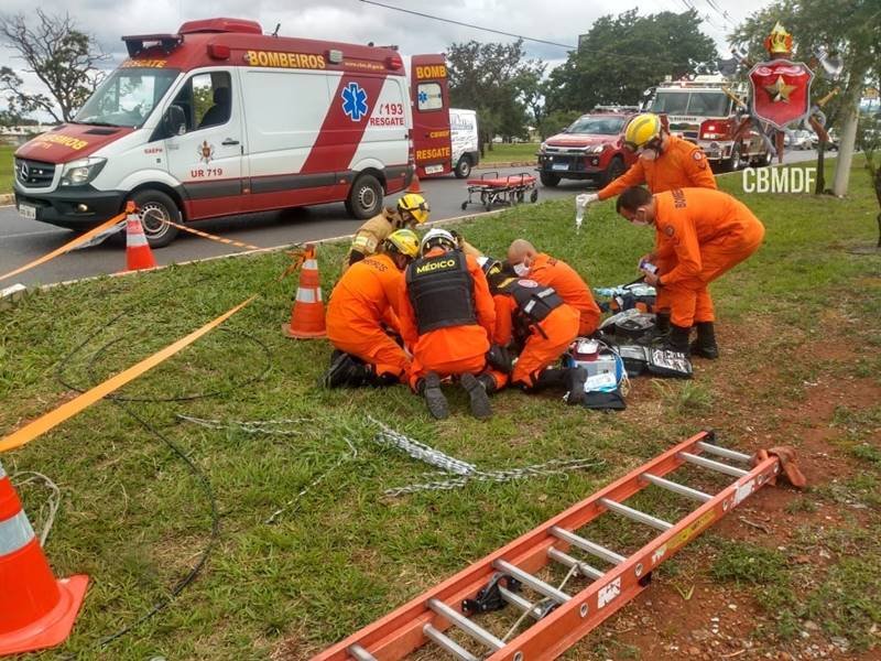 Militares do corpo de bombeiros socorrem homem deitado em maca. Foto colorida