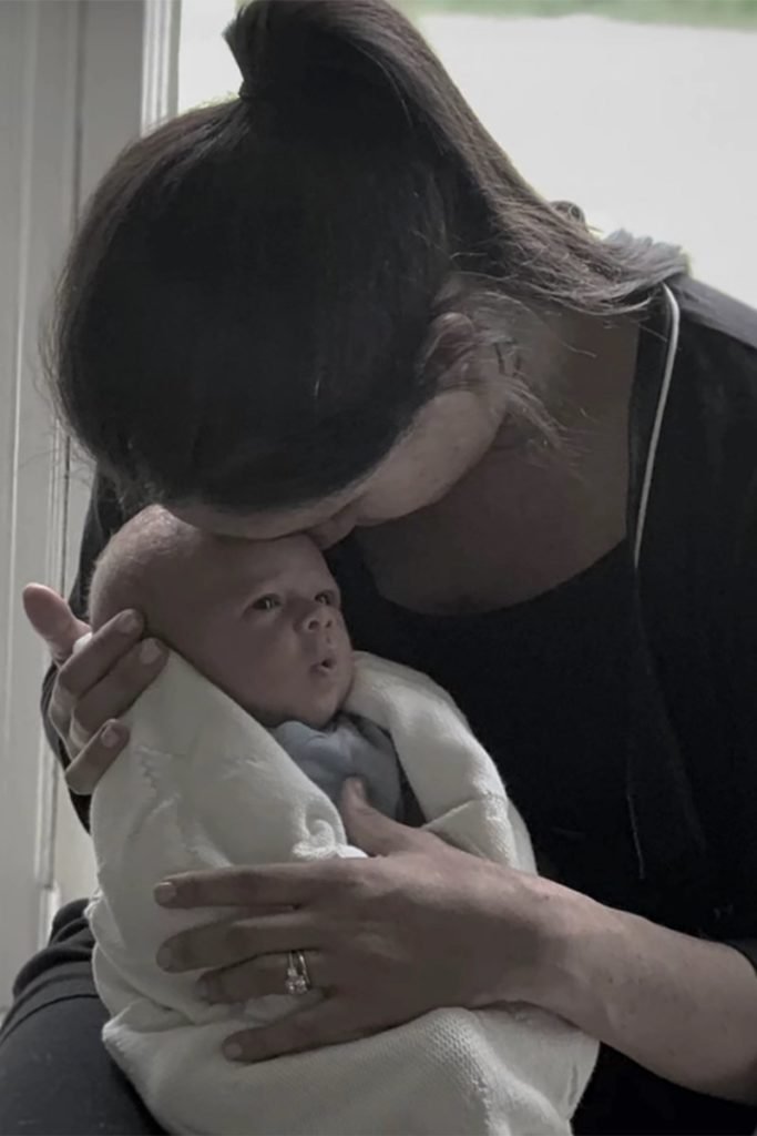 Foto colorida de mulher com a testa colada em testa de bebê - Metrópoles