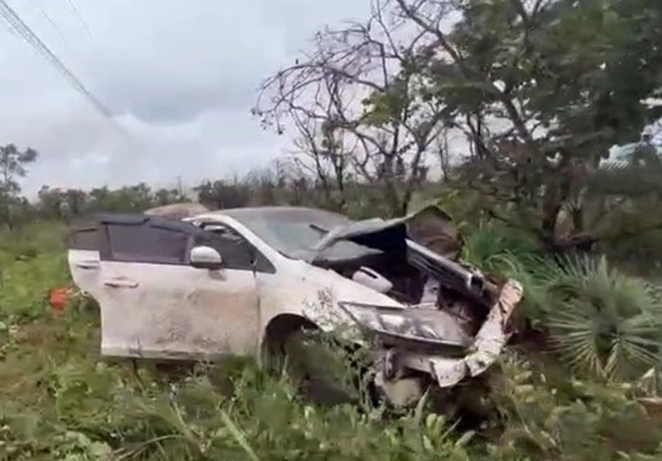 Carro branco destruído em matagal