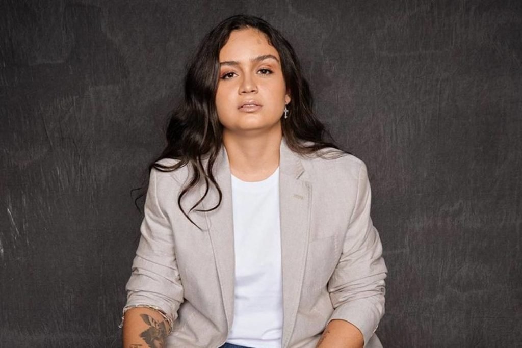 Luiza Martins posa severamente de camiseta branca e blazer cinza - metrópoles