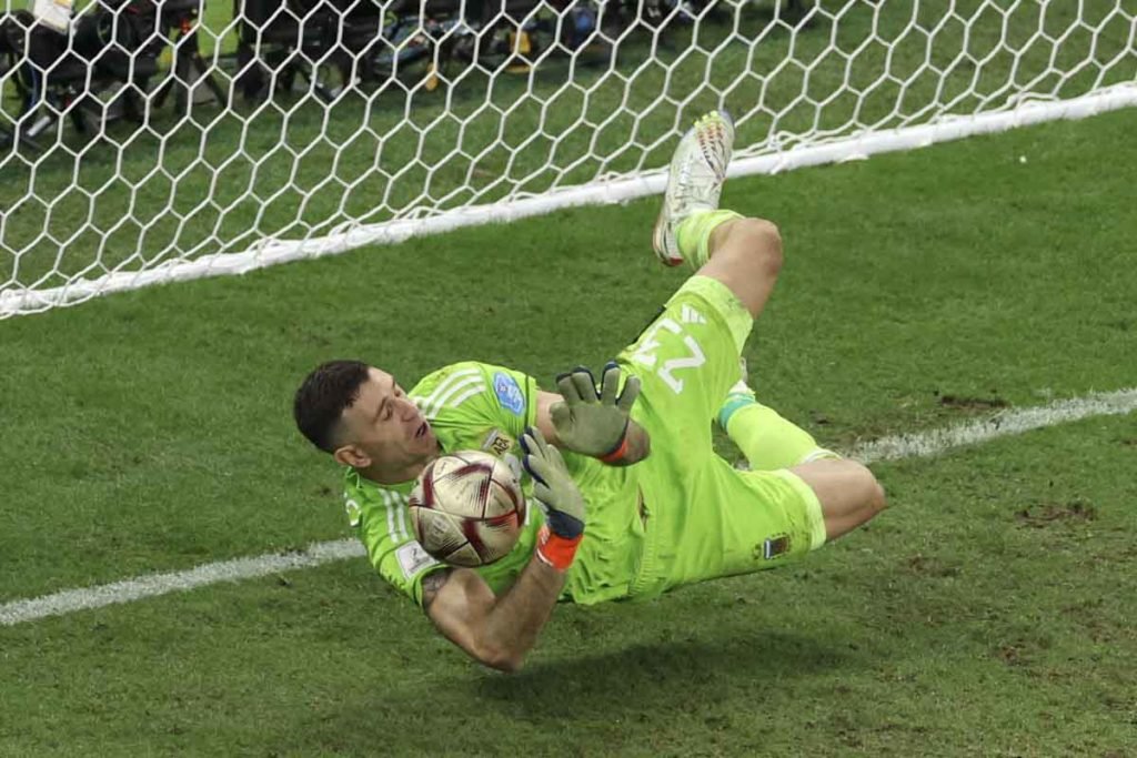Emiliano Martinez, da Argentina, defende o segundo pênalti de Kingsley Coman, da França, na disputa de pênaltis durante a partida final da Copa do Mundo da FIFA Qatar 2022 entre Argentina e França