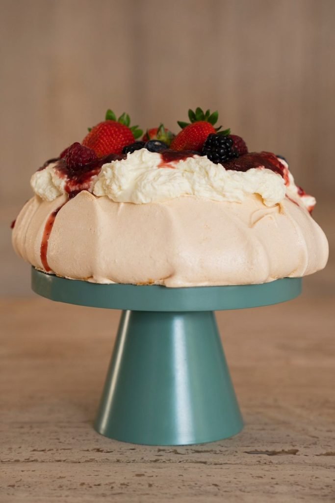 Foto colorida de pavlova com frutas vermelhas no topo - Metrópoles