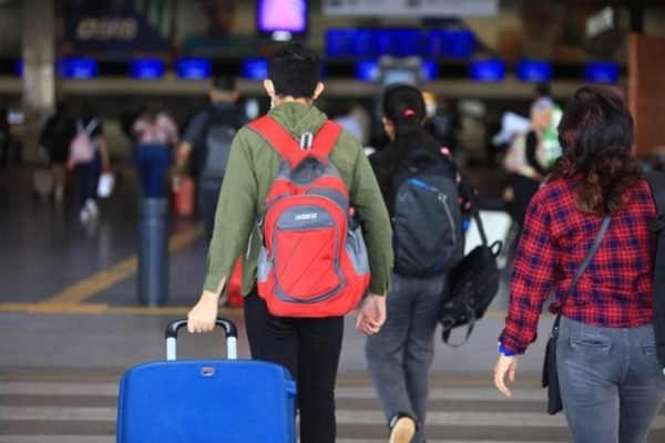 imagem colorida passageiro aeroporto puxa bagagem de mão turismo