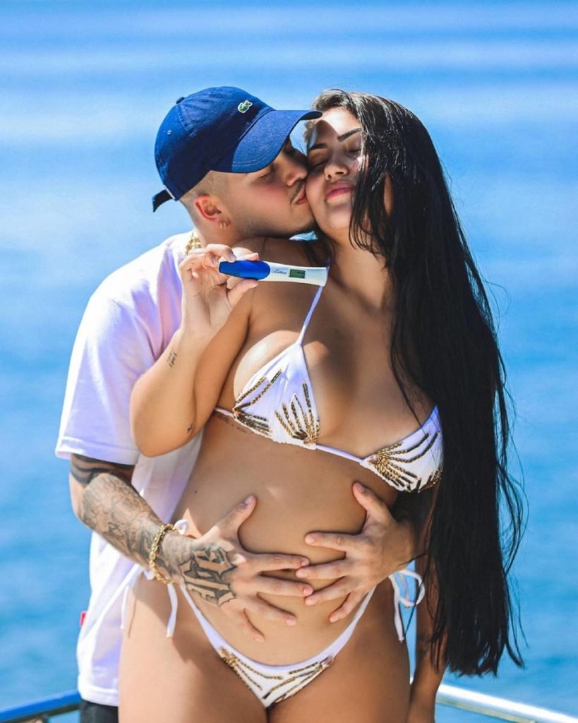 Jottapê beija rosto de Estefany Boro e segura na barriga dela enquanto ela segura teste de gravidez positivo - metrópoles