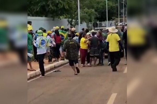 Fotografia colorida de grupo de pessoas em rua com camisetas amarelas