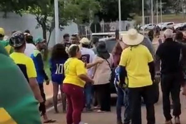 Fotografia colorida de grupo de pessoas em rua com camisetas amarelas