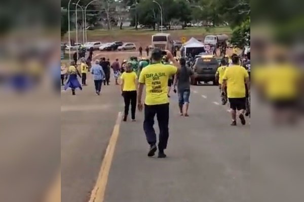 Fotografia colorida de grupo de pessoas em rua com camisetas amarelas