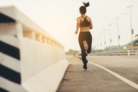 Imagem de mulher correndo no fim do dia na rua - Metrópoles