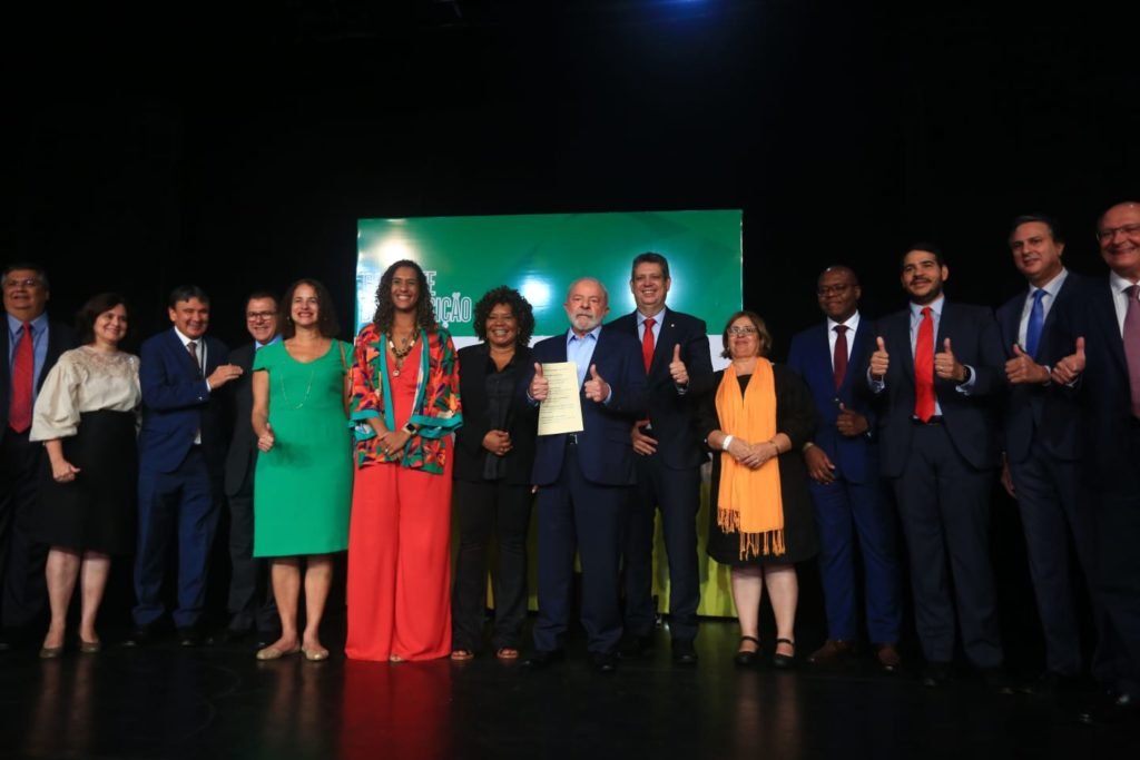 O presidente eleito Lula em coletiva de impresa para anúncio de novos ministros para o próximo governo. Ele e os indicados posam para foto com documento da transição na mão - Metrópoles