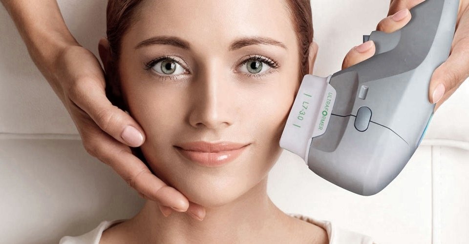 Mãos de profissional aplicando tratamento facial em rosto de mulher - Metrópoles