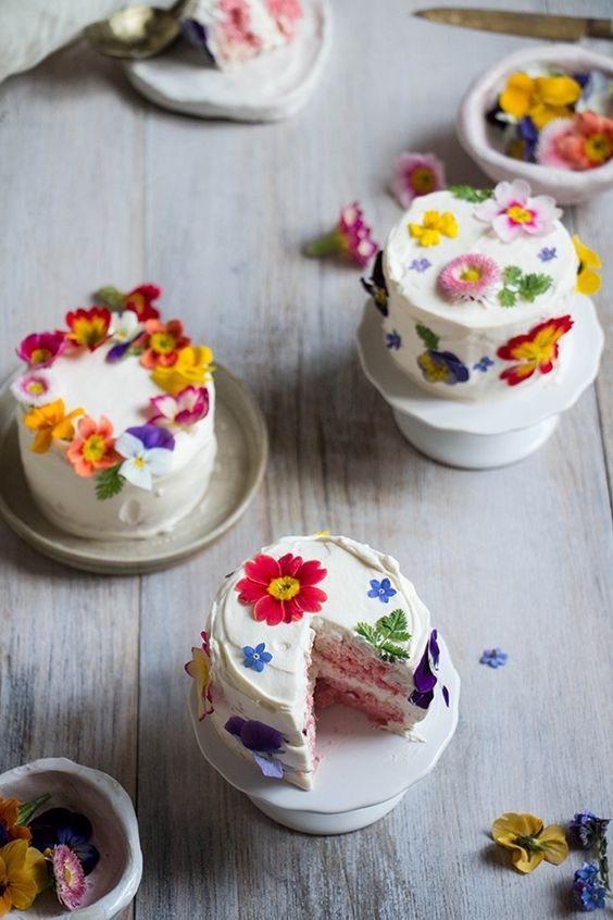 Na imagem, vários bolos pequenos brancos com flores - Metrópooles