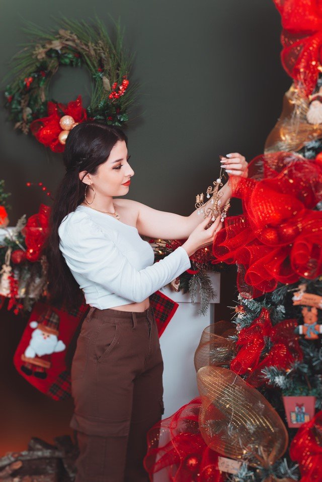 Jovem mulher montando árvore de Natal - Metrópoles