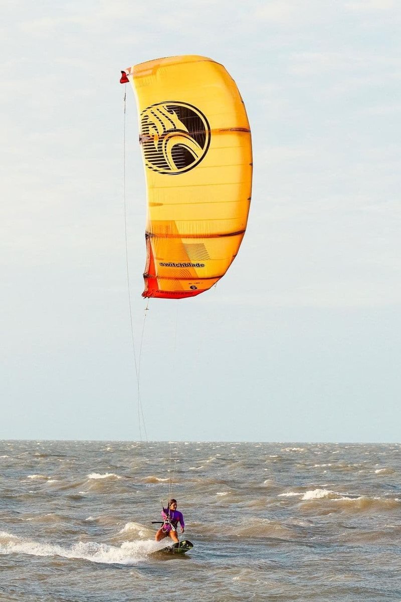Foto colorida de mulher praticando kitesurf - Metrópoles