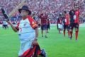 Imagem colorida: torcedor ajoelhado em campo de futebol - Metrópoles