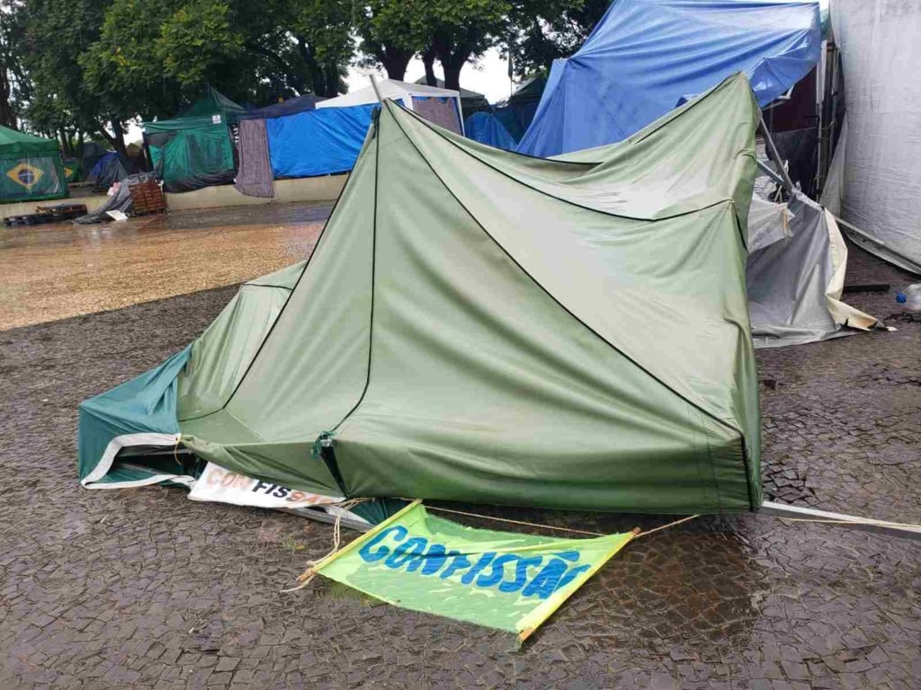 Registros de barracas arrasadas pela chuva no acampamento de militantes bolsonaristas em frente ao QG do Exército de Brasília, com muita lama em volta - Metrópoles
