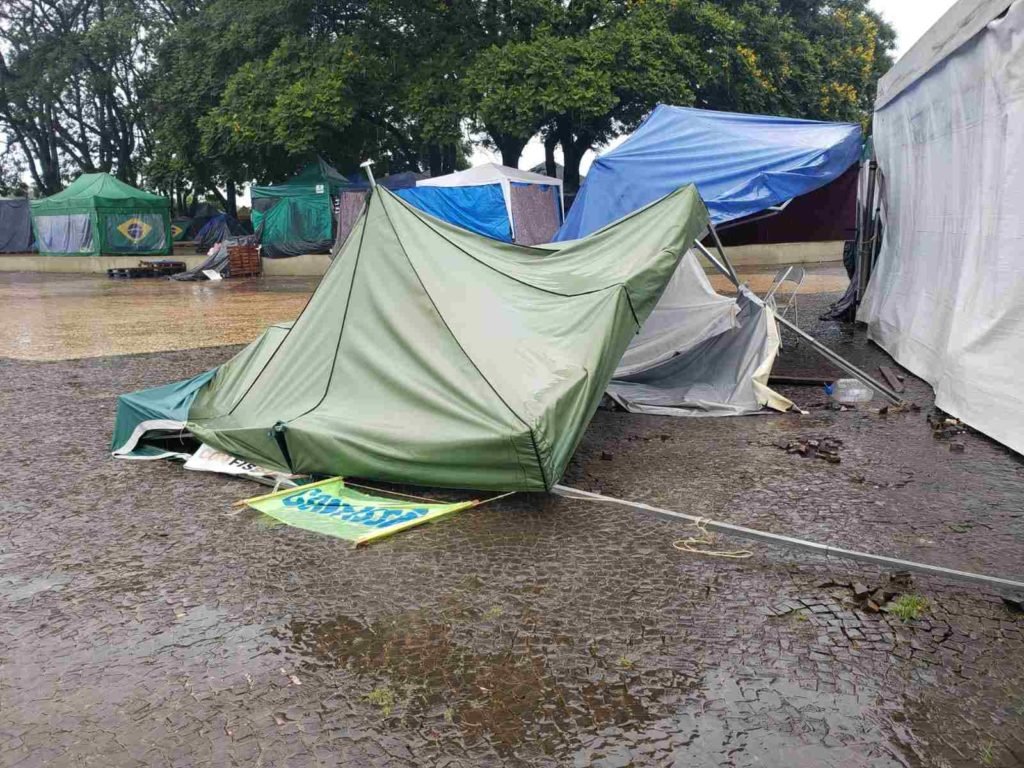 Registros de barracas arrasadas pela chuva no acampamento de militantes bolsonaristas em frente ao QG do Exército de Brasília, com muita lama em volta - Metrópoles