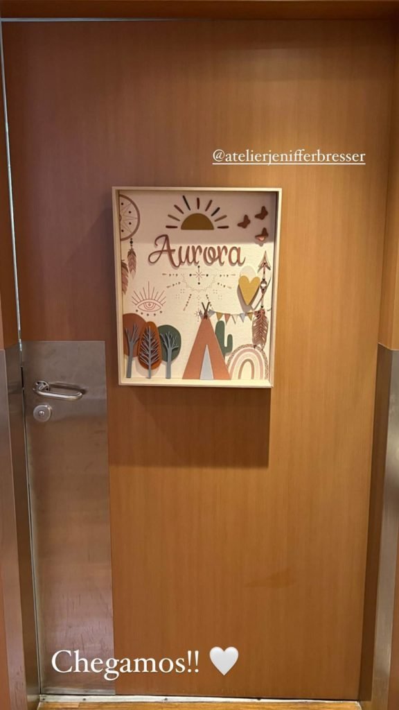 porta de madeira com quadro infantil escrito Aurora - metrópoles