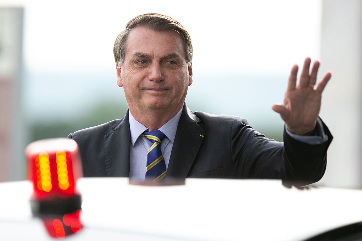 Presidente Jair Messias Bolsonaro fala com apoiadores e acena diante de um carro, na saída do Palácio do Alvorada - Metrópoles
