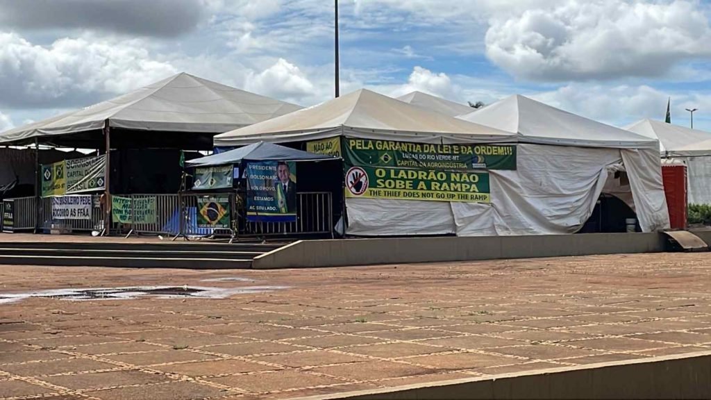 Acampamento bolsonarista no QG do Exército, em Brasília, com movimentação de manifestantes em barracas com faixas - Metrópoles