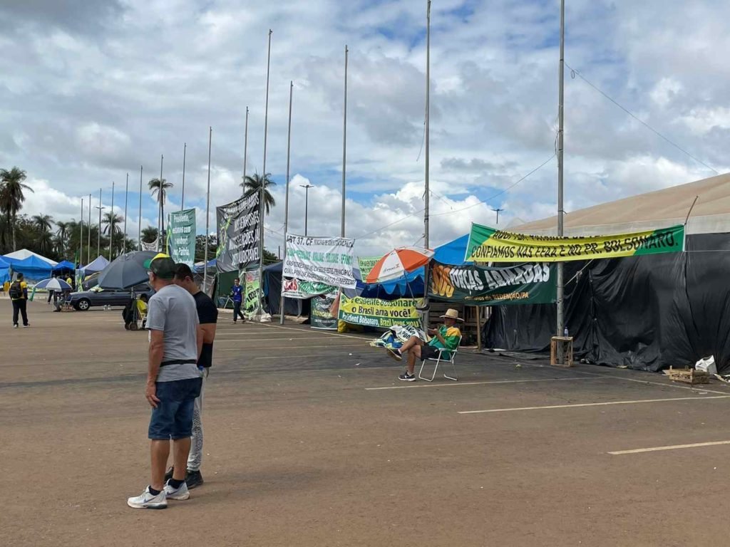 Acampamento bolsonarista no QG do Exército, em Brasília, com movimentação de manifestantes em barracas com faixas - Metrópoles