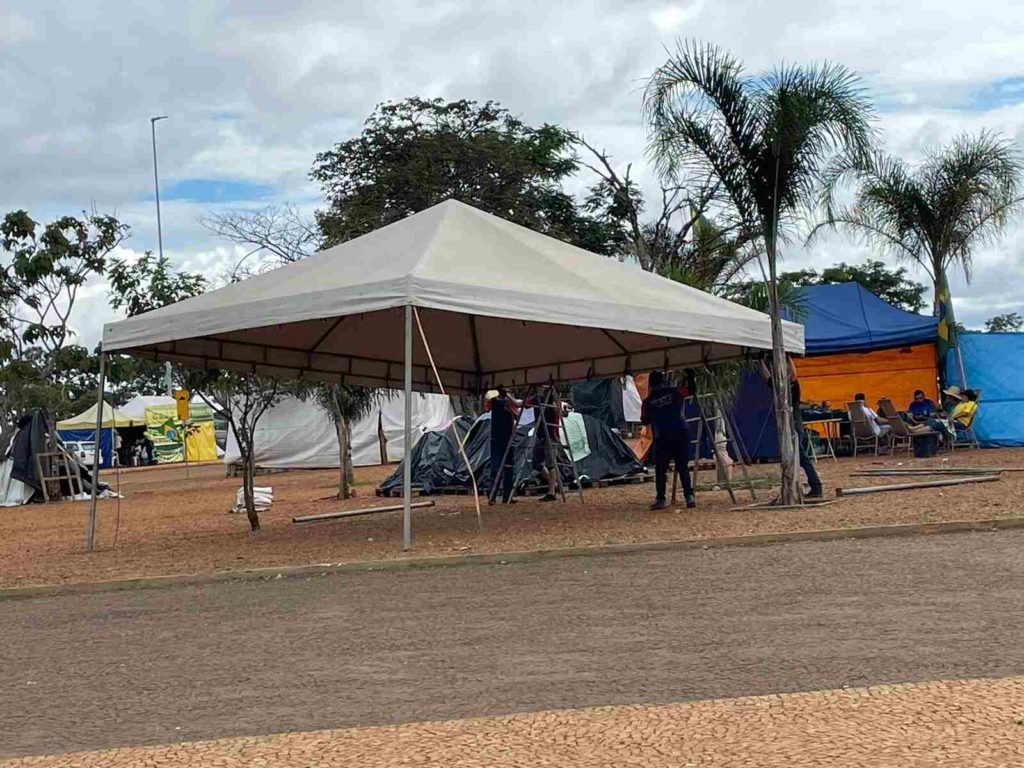 Acampamento bolsonarista no QG do Exército, em Brasília, com movimentação de manifestantes em barracas com faixas - Metrópoles