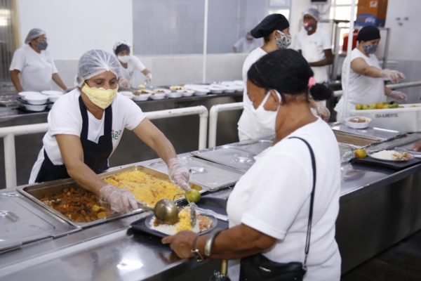 Foto de duas mulheres servindo no bandejão
