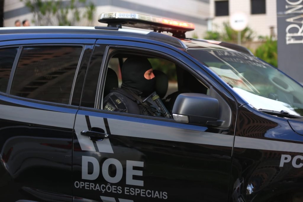 Operação conjunta da Polícia Civil do Distrito Federal e da Polícia Federal prende bolsonaristas autores de ataques terroristas na cidade. Na imagem, dois policiais aparecem uniformizados e armados dentro de viatura - Metrópoles