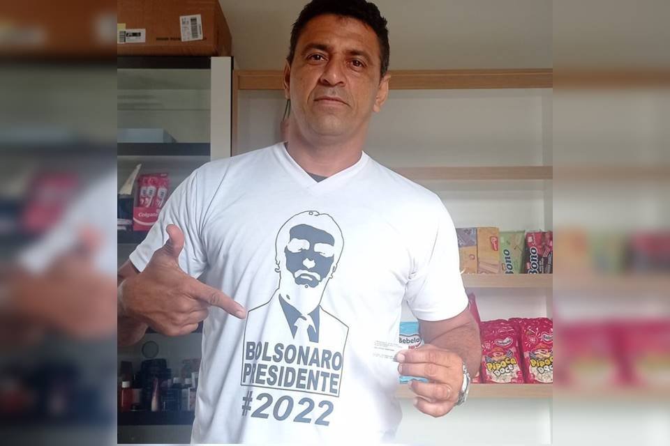 Joel Pires Santana, bolsonarista que foi detido pela PF e pela PCDF em Rondônia. Na imagem ele posa com uma camisa do presidente Bolsonaro, faz sinal de arma e segura seu comprovante de voto - Metrópoles