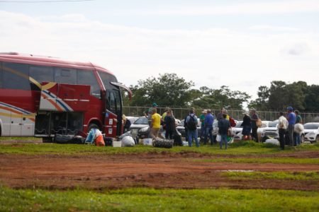 Caravanas de bolsonaristas chegam ao acampamento montado em frente ao QG do Exército. Na imagem, ônibus desembarcam bagagens e pessoas próximo a gramado - Metrópoles