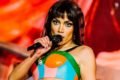 A cantora Anitta segura microfone e canta em festival na Europa, usando peruca lisa e cropped colorido - Metrópoles
