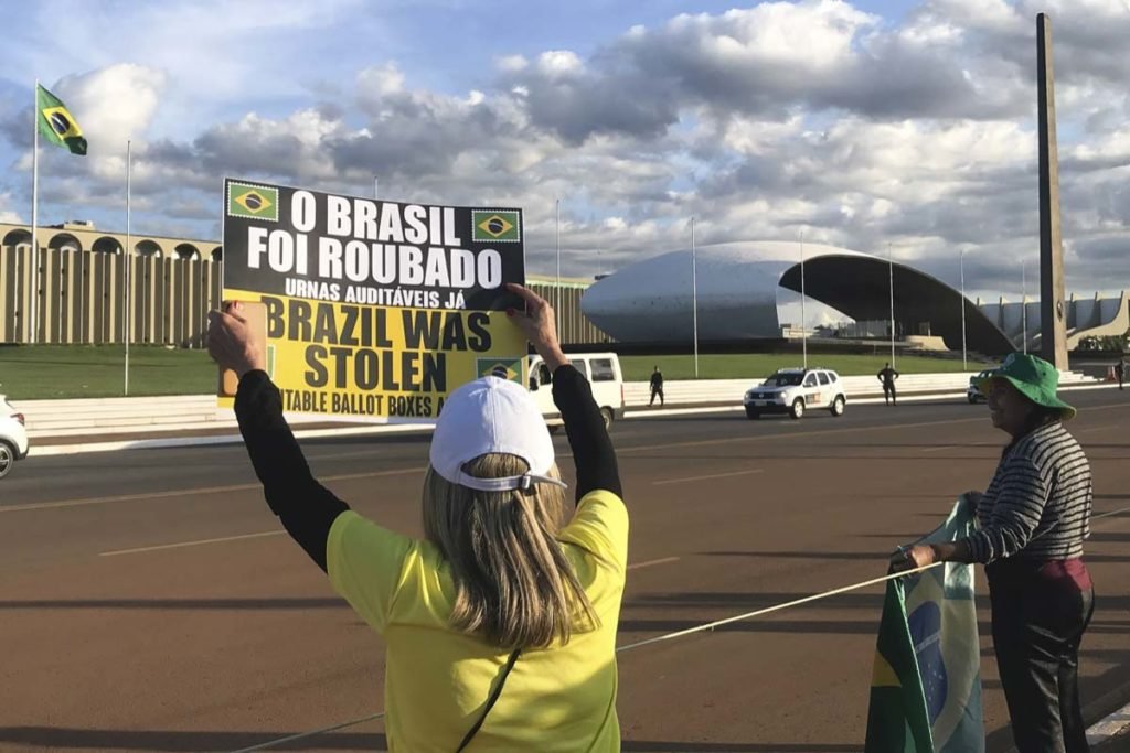 Mulher mostra cartaz com os dizeres Brasil foi roubado - Metrópoles