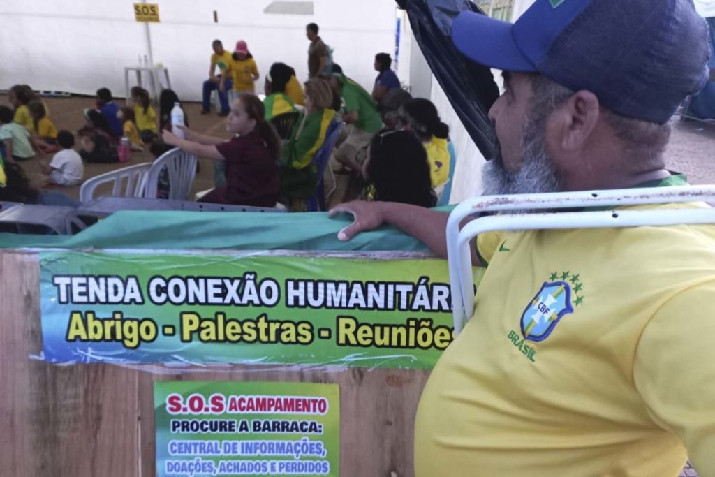 homem observa crianças brincando em ato bolsonarista em frente ao QG do exército - Metrópoles