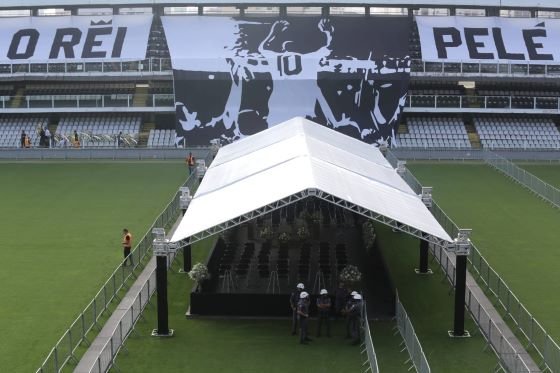 Estrutura montada no campo da Vila Belmiro, estádio do Santos, para o velório do ex-jogador Pelé. Ao fundo, na arquibancada, é possível ver um bandeira com a silhueta do atleta e os dizeres "O rei Pelé" - Metrópoles