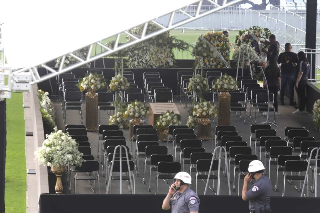 Estrutura montada no campo da Vila Belmiro, estádio do Santos, para o velório do ex-jogador Pelé. Ao fundo, na arquibancada, é possível ver um bandeira com a silhueta do atleta e os dizeres 