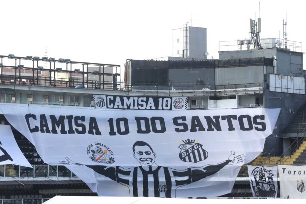 Estrutura montada no campo da Vila Belmiro, estádio do Santos, para o velório do ex-jogador Pelé. Ao fundo, na arquibancada, é possível ver um bandeira com a silhueta do atleta e os dizeres 