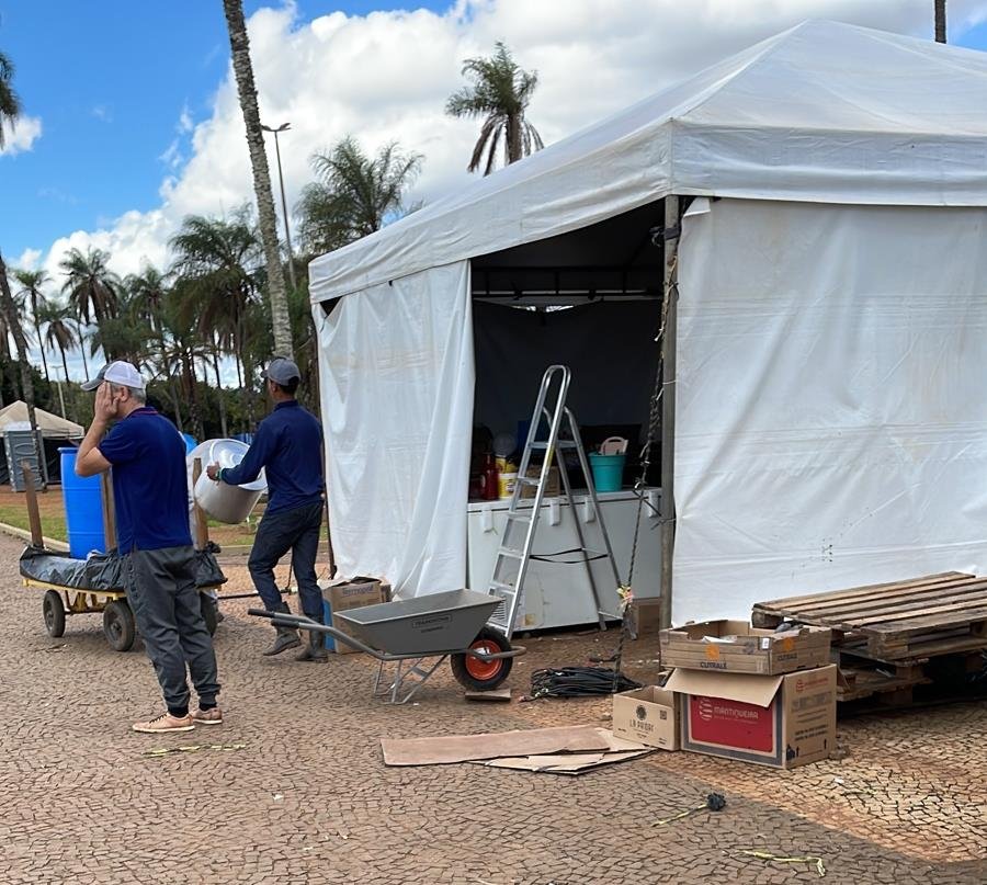 Acampamento bolsonarista no QG do Exército amanhece vazio, com estruturas desfeitas e lixo nas ruas após a posse do presidente Lula. No detalhe, homens desarmam toldo - Metrópoles