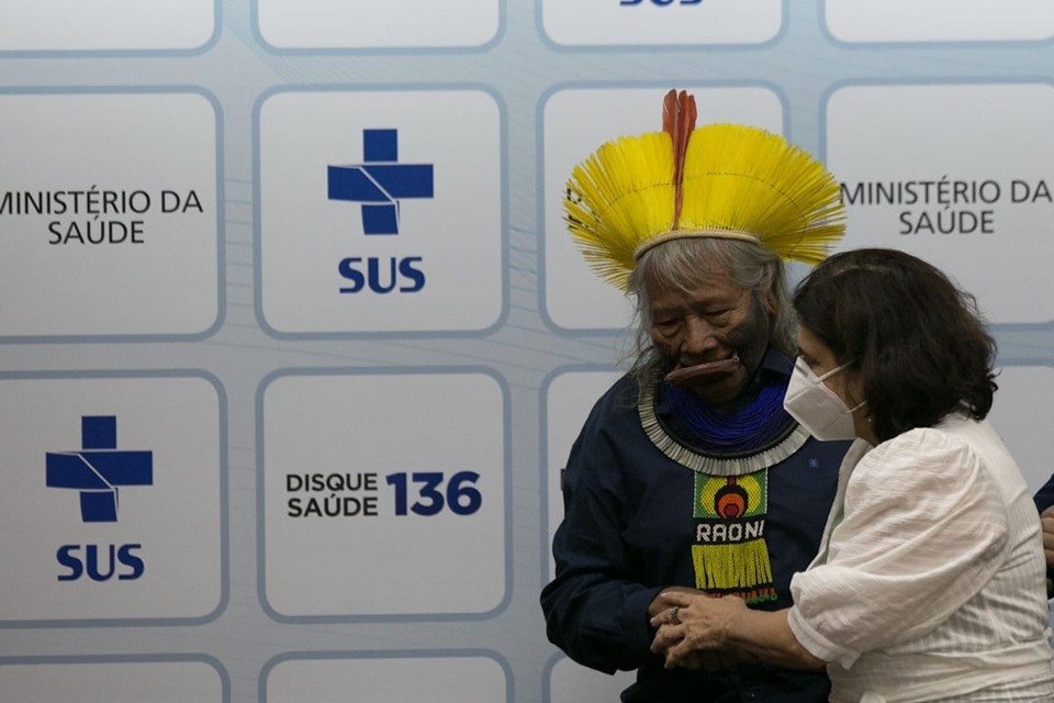 Nisia Trindade toma posse como ministra da Saúde em cerimônia no ministério. Ela usa máscara e segura a mão do cacique indígena Raoni - Metrópoles