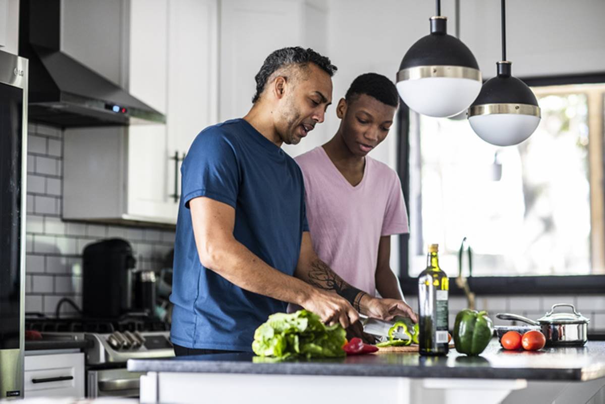 Homens em frente a mesa com ingredientes saudáveis para cozinhar