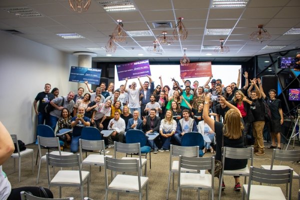 Pessoas levantam cartazes em sala de aula em referência ao projeto Projeto CocreationLab